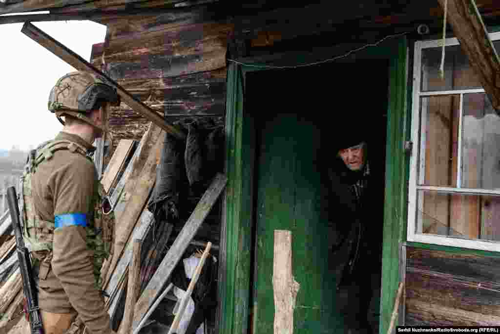 Военный 10-й отдельной горно-штурмовой бригады "Эдельвейс" Никита Шандиба уговаривает 82-летнего мужчины Валентина покинуть опасную зону. В марте 2022 года село Тетеревское в Киевской области наполовину сравняли с землей. Дом Валентина был частично поврежден обстрелами. Когда военные и журналисты случайно увидели силуэт мужчины и зашли внутрь, русская артиллерия начала обстрел. Валентин не хотел покидать дом, в котором прожил 50 лет, но его удалось уговорить эвакуироваться. Село Тетеревское, Киевщина, март 2022 года / Фото справа сделано в марте 2024 года