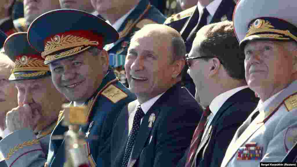 В 2013 году во время парада продемонстрировали новые военные вертолеты Ка-52 и Ми-28, новые истребители Су-34 и модернизированные самолеты Су-27 и МиГ-29. На фото слева направо: министр обороны Сергей Шойгу, президент России Владимир Путин, премьер-министр Дмитрий Медведев