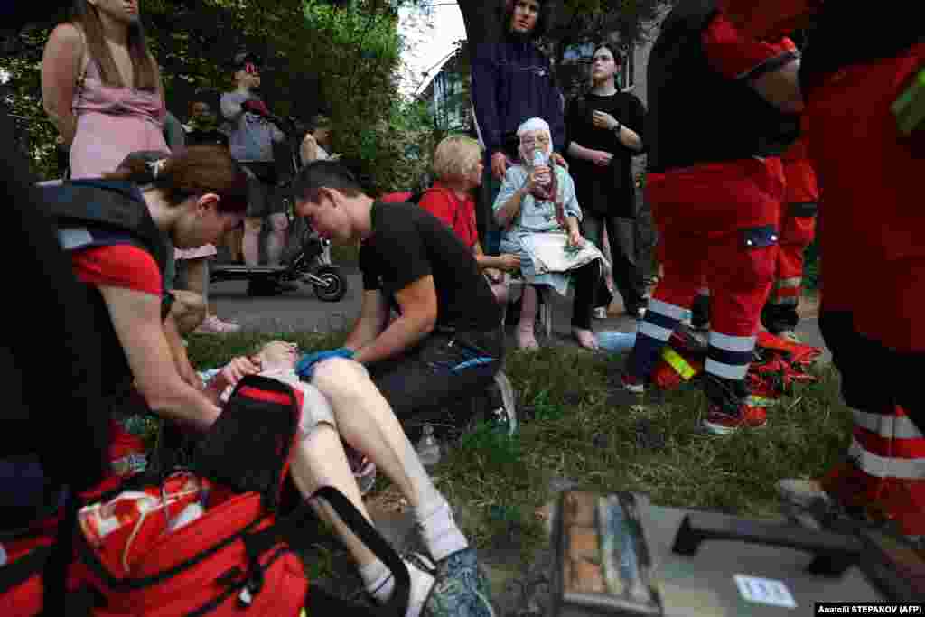 Медицинские работники оказывают помощь местным жителям, пострадавшим во время ракетного удара в Киеве, 8 июля 2024 года, фото AFP