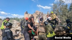 Спасатели выносят пострадавших от ракетного удара по жилому дому в Кривом Роге, 12 июня 2024 года