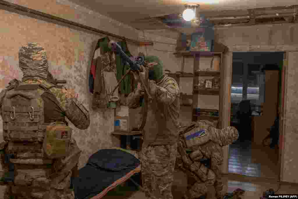 25 сентября. Украинский военный с позывным "Кузя" из элитного подразделения ВСУ "Призраки Бахмута" проверяет прицел. Он собирается на задание всего в нескольких сотнях метров от позиций российских войск на востоке Украины. Бои на том участке фронта – это преимущественно окопная война и дальние артиллерийские дуэли. Однако Кузя считает, что работа снайперов очень важна, она помогает украинским войскам продвигаться вперед