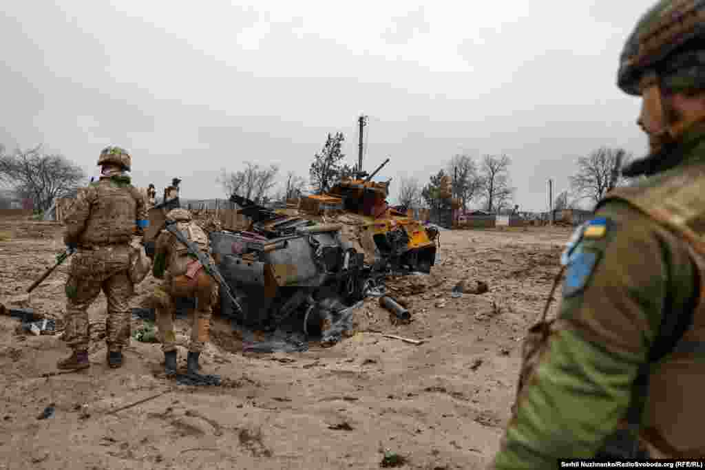 Украинские военные 10-й отдельной горно-штурмовой бригады "Эдельвейс" осматривают уничтоженный российский бронетранспортер БТР-82 в деревне Тетеревское у линии фронта, март 2022 года / Справа фото, сделанное в марте 2024 года. На месте БТР осталась только воронка в песке, уничтоженную технику давно вывезли