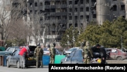 Военнослужащие пророссийских войск проверяют автомобили мирных жителей в Мариуполе, Украина, 20 марта 2022 года
