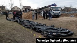 Тела мирных жителей, которые, по словам украинских официальных лиц, были убиты во время вторжения России, а затем эксгумированы из братской могилы в городе Буча под Киевом, Украина, 8 апреля 2022 года