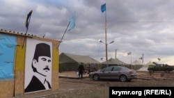Участники акции по блокаде Крыма на КПП "Чонгар" под портретом Челебиджихана