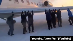 Krasnoyarsk, Igark. Men push the plane, which is frozen to the runway. 26 Nov 2014