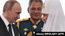 Владимир Путин с патриархом Кириллом и главой Минобороны Сергеем Шойгу