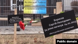 Кресты с именами погибших при обстреле Мариуполя около посольства России