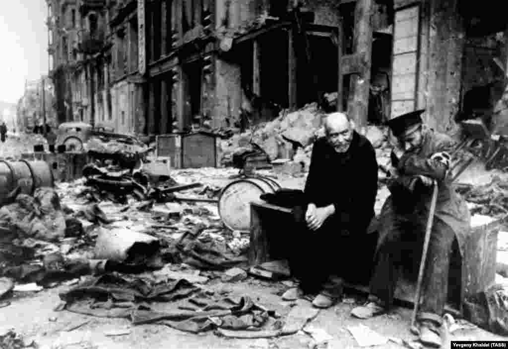 Слепой мужчина (справа) с проводником на разрушенной улице Берлина в 1945 году. Халдей вспоминал, что спросил мужчину на немецком, откуда они пришли. Слепой ответил: "Мы больше не знаем. Мы не знаем, откуда мы пришли, или куда мы идем"