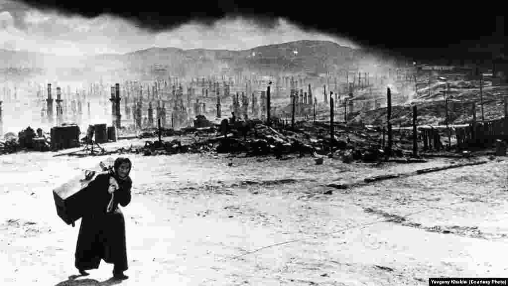 Советский Мурманск после того, как нацистские войска в 1942 году уничтожили весь северо-запад города зажигательными бомбами: за сутки их было сброшено более 350 штук. Халдей вспоминал, что женщина ругала его за то, что он фотографировал разрушения. "Почему вы вам не поехать в Берлин и снять, как наши пилоты бомбят их?" – говорила она. Фотограф пообещал ей, что, если когда-нибудь доберется до Германии, он "именно это и сделает"