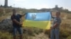 Активисты с украинским флагом на горе Митридат в Крыму 24 августа 2015 года