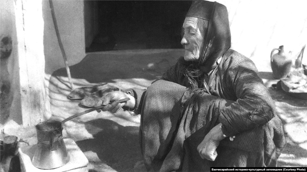 Приготовление кофе. Бахчисарай, 1920-е Кофе – основополагающий элемент не только крымскотатарской кухни, но и культуры в целом. Для его приготовления пользовались ручной кофеваркой, в каждом доме на столе стоял кофейник. К кофе предлагали халву, а также разнообразные варенья. В конце XIX века в Бахчисарае были 62 кофейни