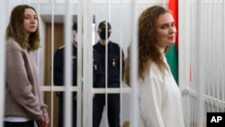 Журналистки Дарья Чульцова (слева) и Катерина Андреева в клетке для обвиняемых в зале суда в Минске, Беларусь, 18 февраля 2021 года