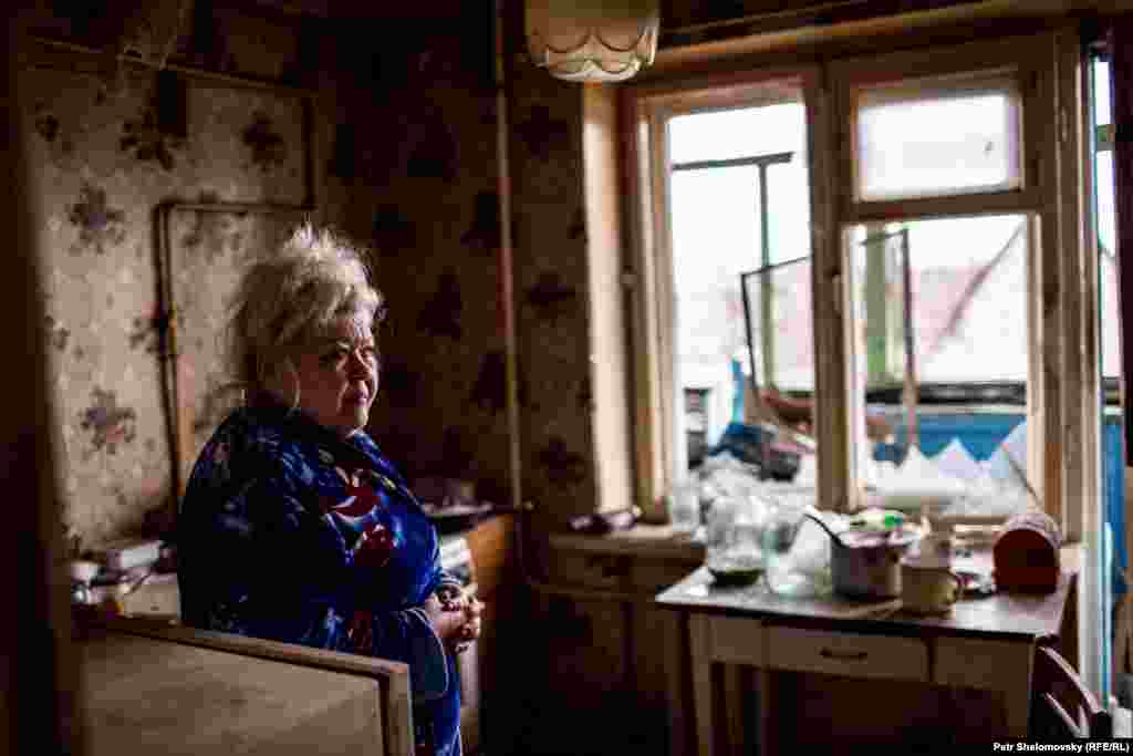 Вера показывает разрушения, причиненные ее дому  