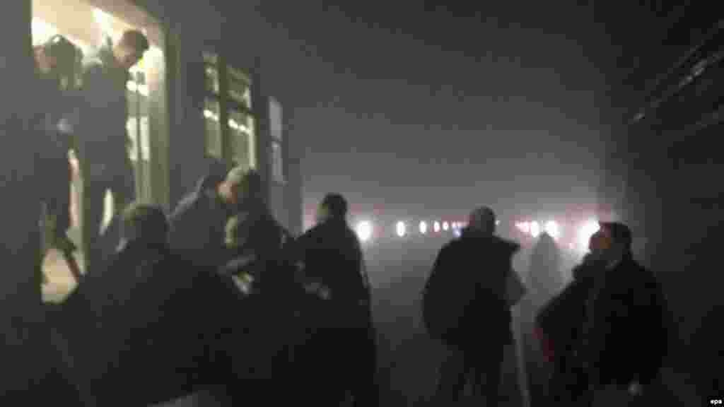 Пассажиры выходят из поезда метро в туннель между станциями Арс-Луа и Маельбек после взрыва на станции Маельбек в центре Брюсселя