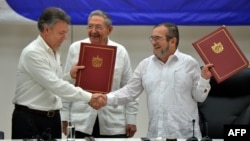 Президент Колумбии Хуан Мануэль Сантос и глава группировки FARC Тимолено Хименес ("Тимошенко") заключают соглашение о перемирии