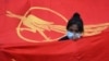 Девушка на фоне флага "Национальной лиги за демократию" во время протеста против военного переворота в Янгоне 7 февраля