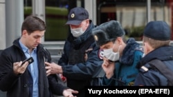Полицейские проверяют документы прохожего в период самоизоляции в Москве. 9 апреля