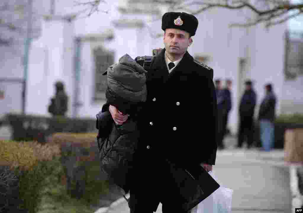 Украинский офицер покидает базу южной штаб-квартиры военно-морского флота в Новоозёрном после того, как она была захвачена российскими войсками, 19 марта 