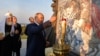 Путин зажигает свечу у мемориала Александру Невскому в Самолве
