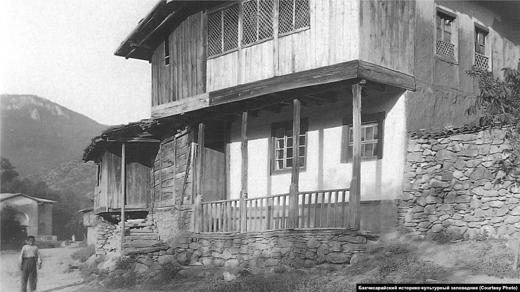 Сельский дом. Юго-Западный Крым, 1920-е В типичной общей комнате дома был открытый камин с дымоходом и подвешенный к нему на цепи казан. Вдоль стен стояли низкие диванчики с матрацами и подушками, рядом – столики. Для украшения стен использовались многочисленные полотенца, а для пола – ковры