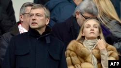 Российский миллиардер Дмитрий Рыболовлев на футбольном матче между Сент-Этьен и Монако на стадионе "Джеффрой Гишард" рядом с неизвестной женщиной, 1 марта 2014 года