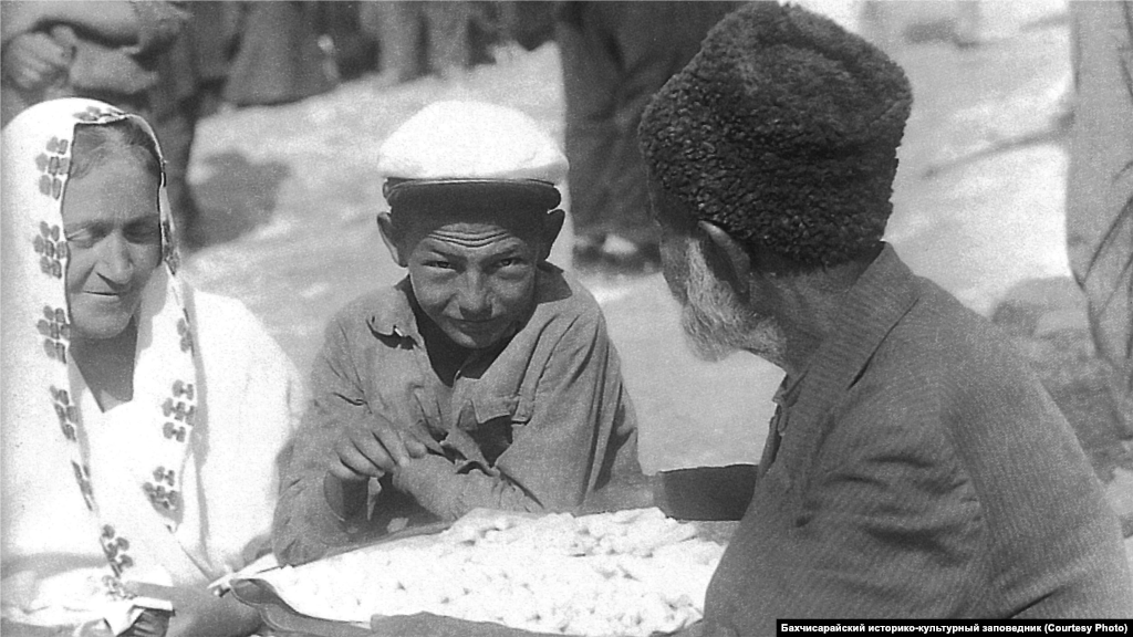 Уличный торговец. Бахчисарай, 1920-е Большинство ремесленников сами продавали изготовленный ими товар в собственных лавках, но крымский город невозможно представить без базара. Существовала и разносная торговля – коробейники, обвешанные ожерельями, цепочками, платьями, чубуками и другими предметами, ходили по городским улицам